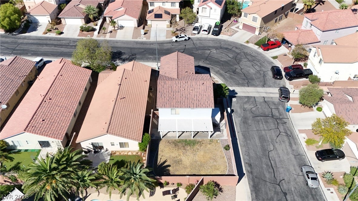 An aerial perspective showcases a neat residential setting featuring classic tile roofing and paved driveways.
