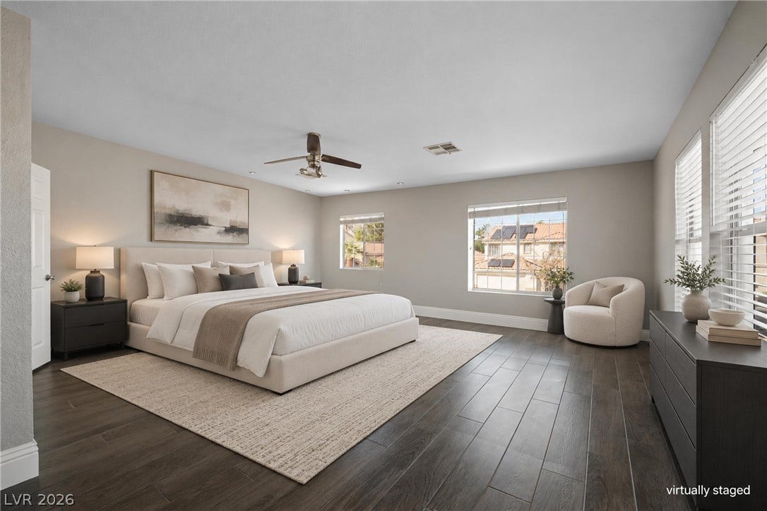 Rich wood plank flooring sets a refined tone in this generously proportioned bedroom.