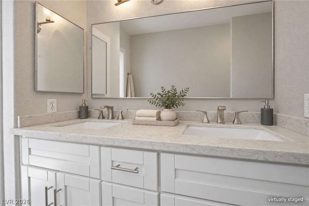 Double undermount sinks accent the stone vanity within this bathroom oasis.