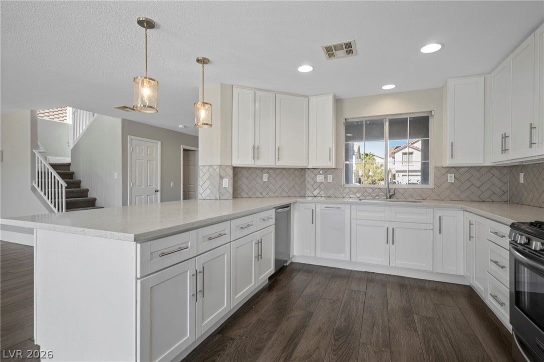 Gleaming stone countertops and classic cabinetry elevate this open culinary space with rich wood floors.