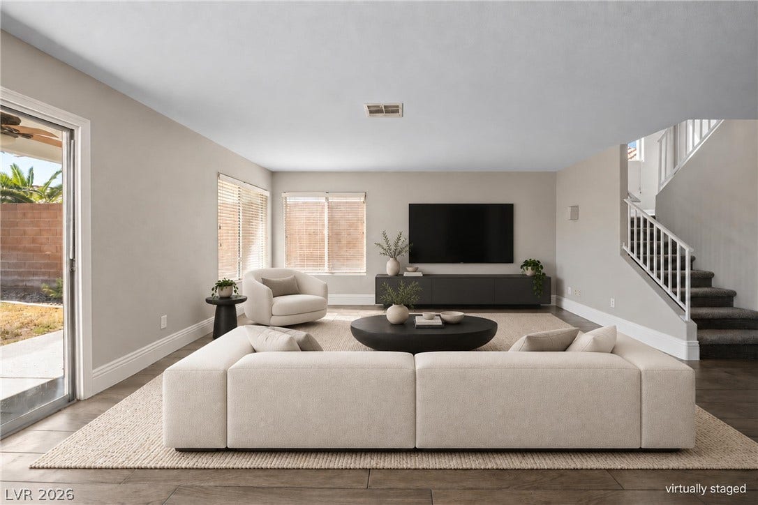 An open living room features wood-look tile flooring and sliding glass door access.