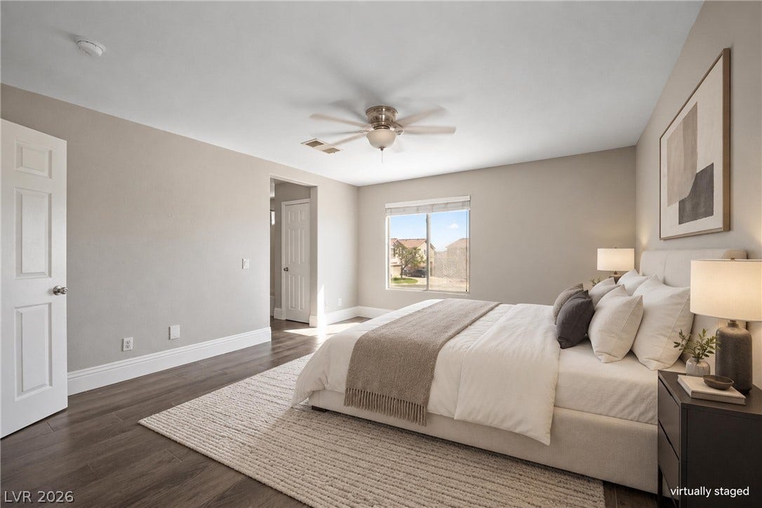Gleaming hardwood floors and a bright window elevate this classic primary bedroom.