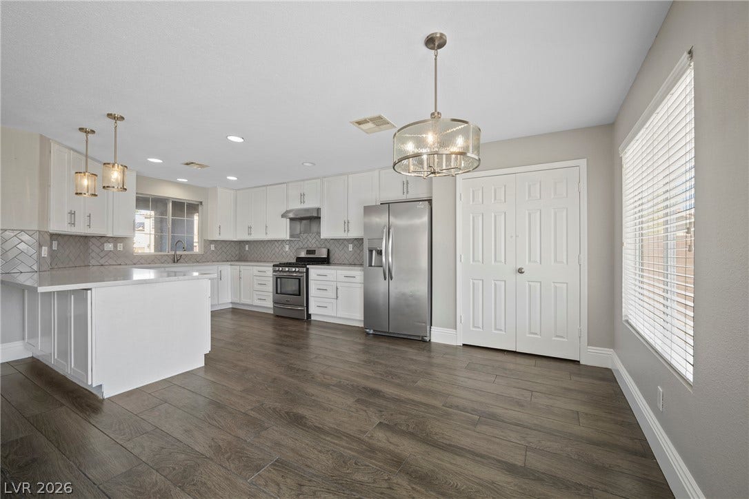 Rich wood-look flooring anchors this open culinary space under smooth ceilings.