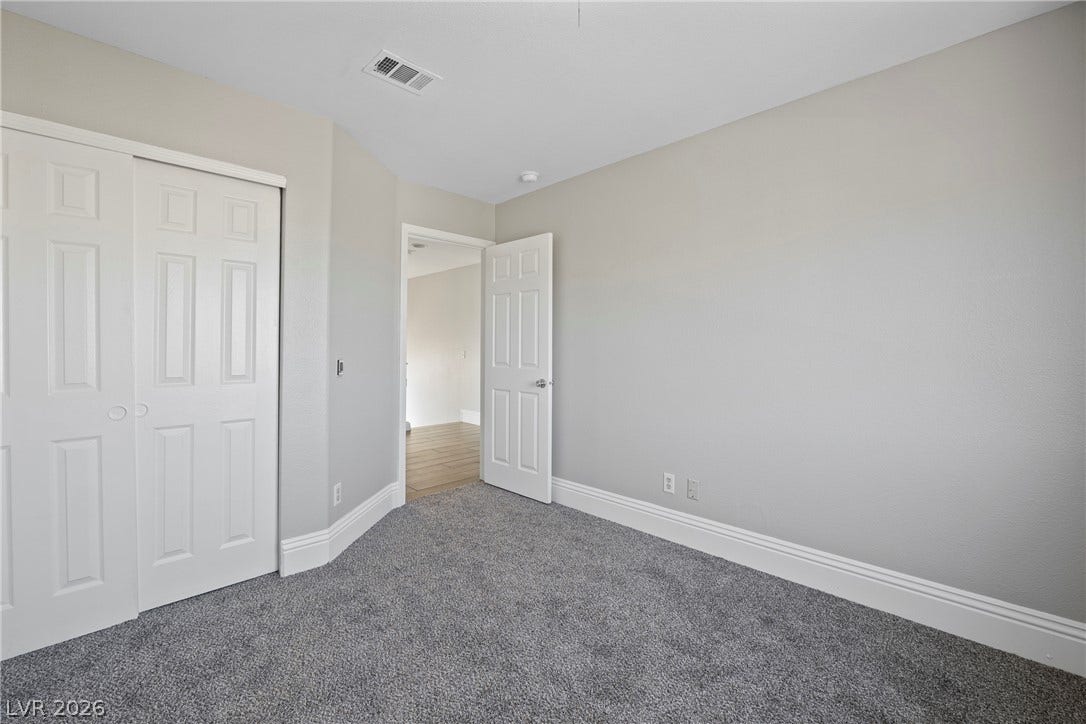 Plush carpeting and crisp white baseboards define this versatile auxiliary bedroom space.