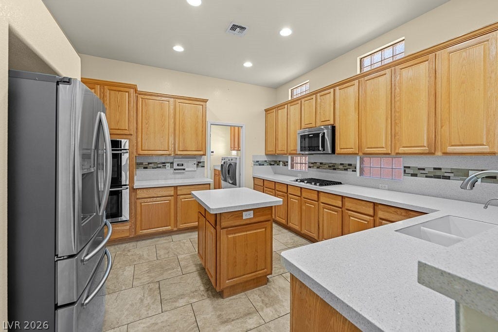 An inviting kitchen with warm wooden cabinetry and elegant countertops awaits culinary adventures.