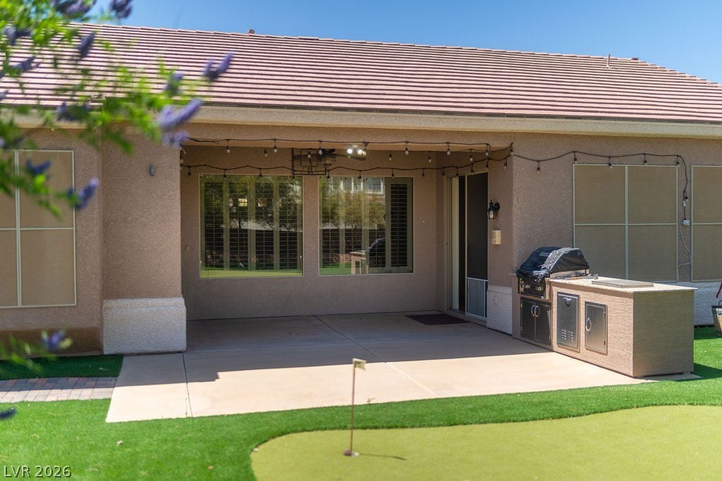 This inviting patio features an outdoor kitchen, perfect for alfresco dining and entertaining.
