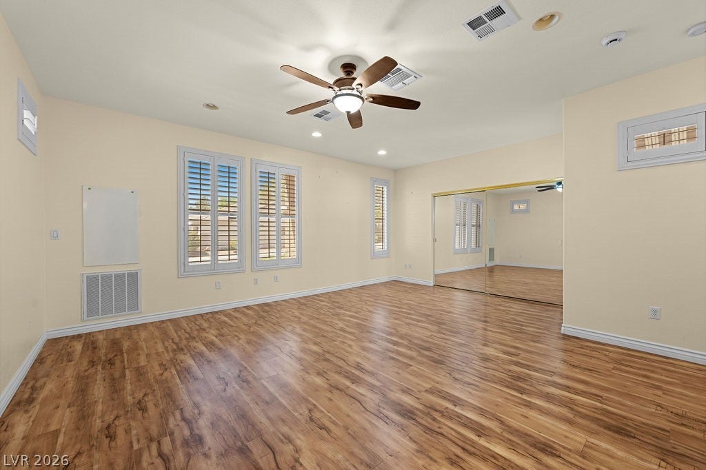 This bright bedroom features beautiful flooring and ample natural light, creating a comfortable living space.