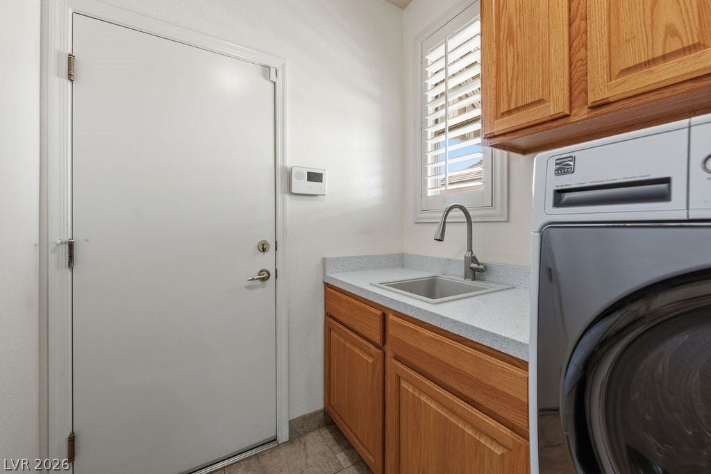 This functional laundry room features a convenient utility sink and efficient appliances for daily tasks.