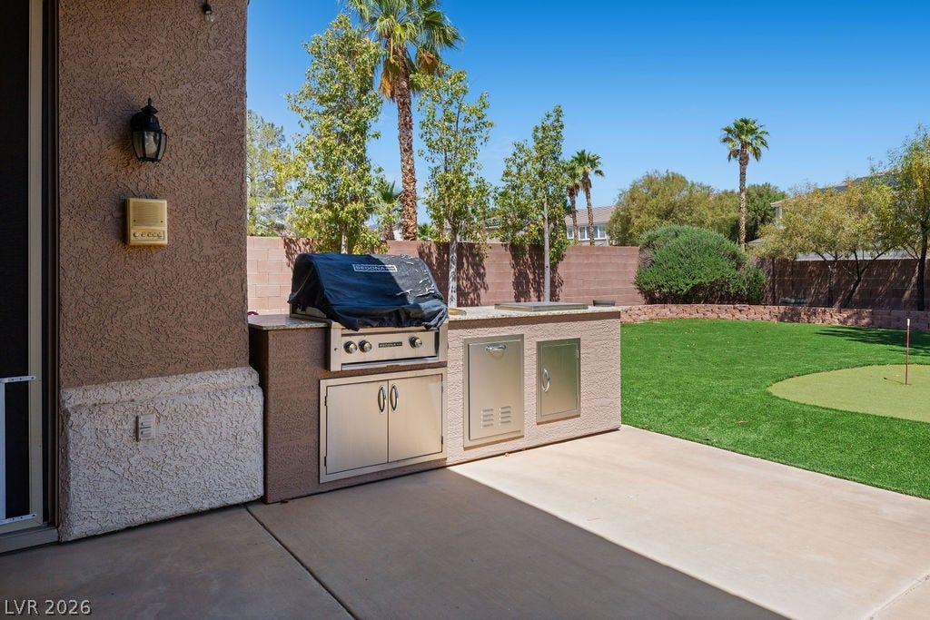 This inviting outdoor space features an outdoor kitchen, ideal for al fresco dining and entertaining.
