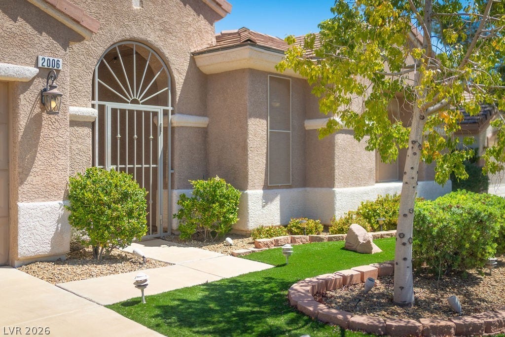 This charming home offers a welcoming facade with thoughtfully designed landscaping.