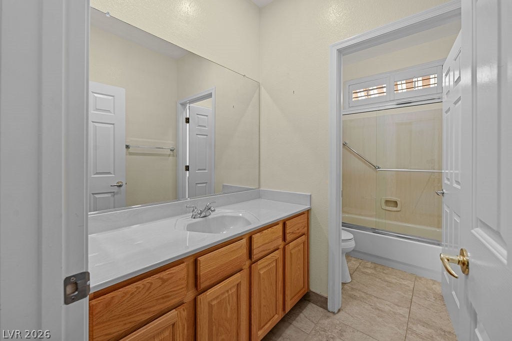 This bathroom features a sleek vanity and convenient shower, offering comfort and style.