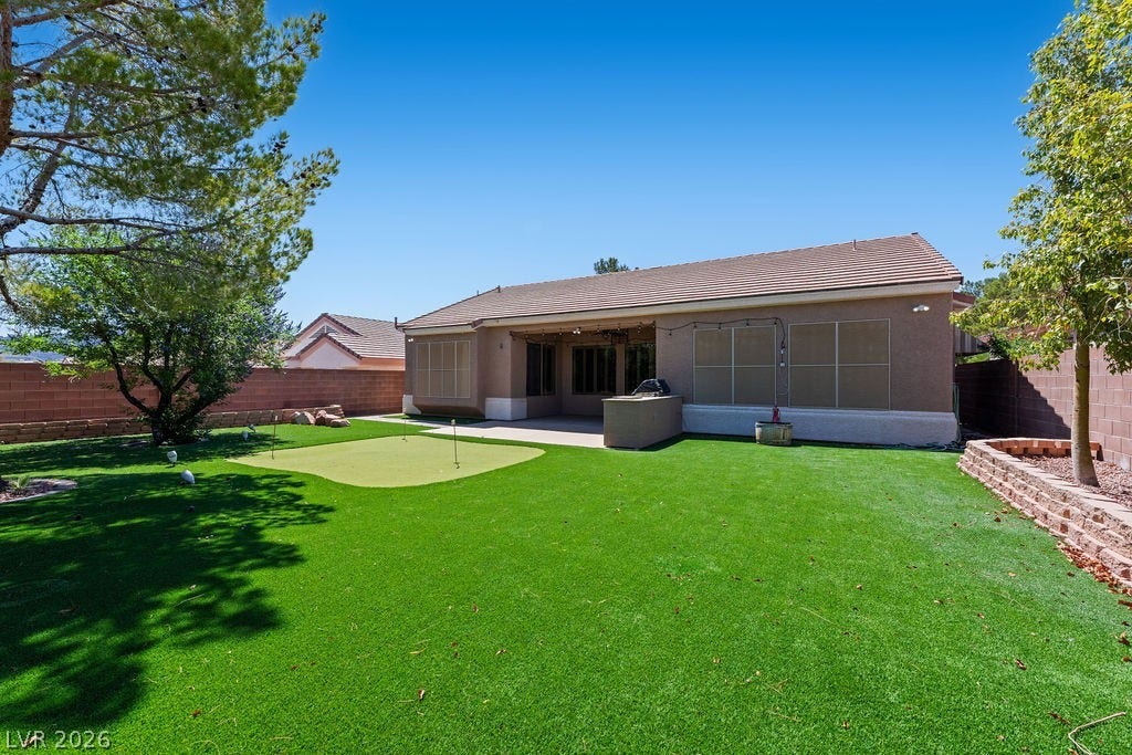Enjoy outdoor living in this expansive yard with a dedicated putting green and ample patio space.