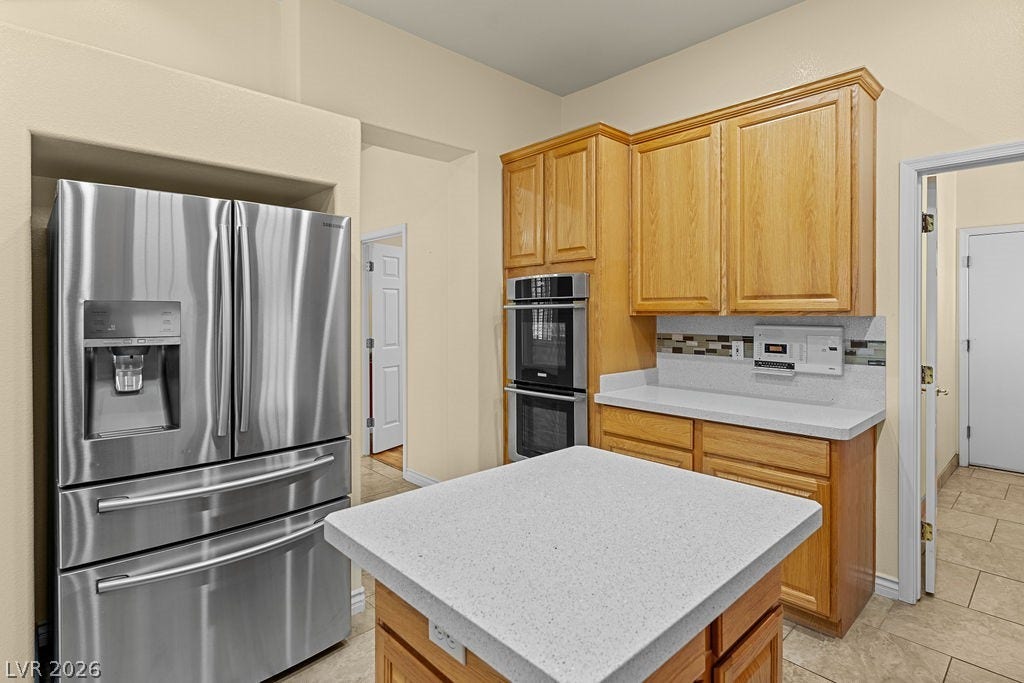 This spacious kitchen offers ample storage and a functional layout, perfect for daily living and entertaining.