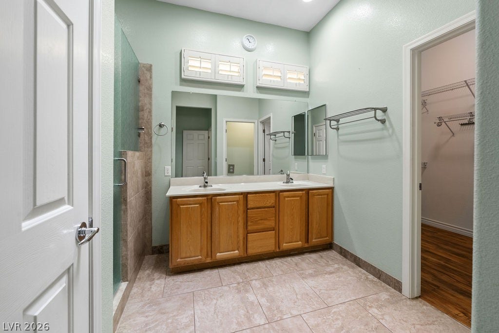 This bathroom features a double vanity and an adjacent walk-in closet for effortless daily routines.