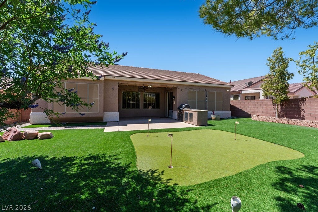 This private yard features a putting green and an outdoor kitchen for leisure and entertainment.