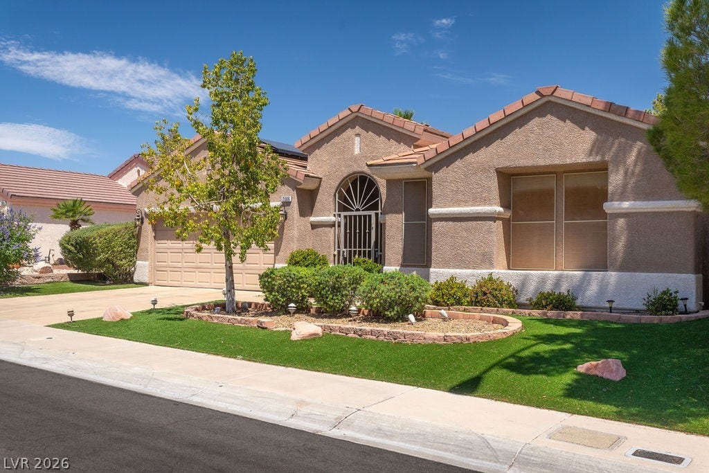 This charming home features a stucco exterior and a neatly landscaped front yard.