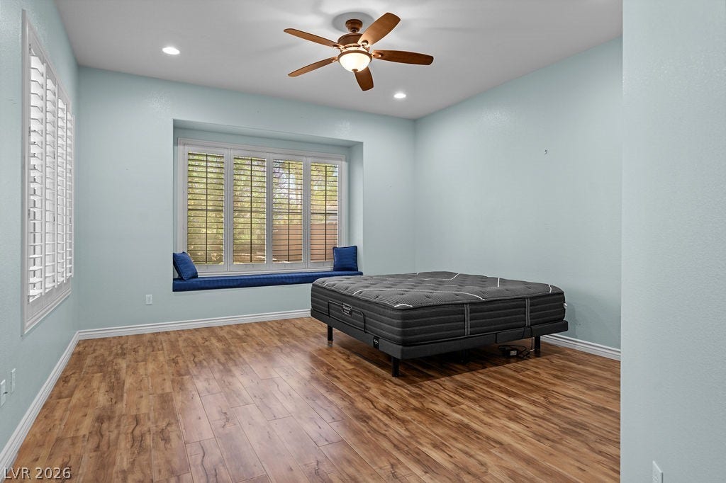 This spacious bedroom offers ample natural light and a serene ambiance.