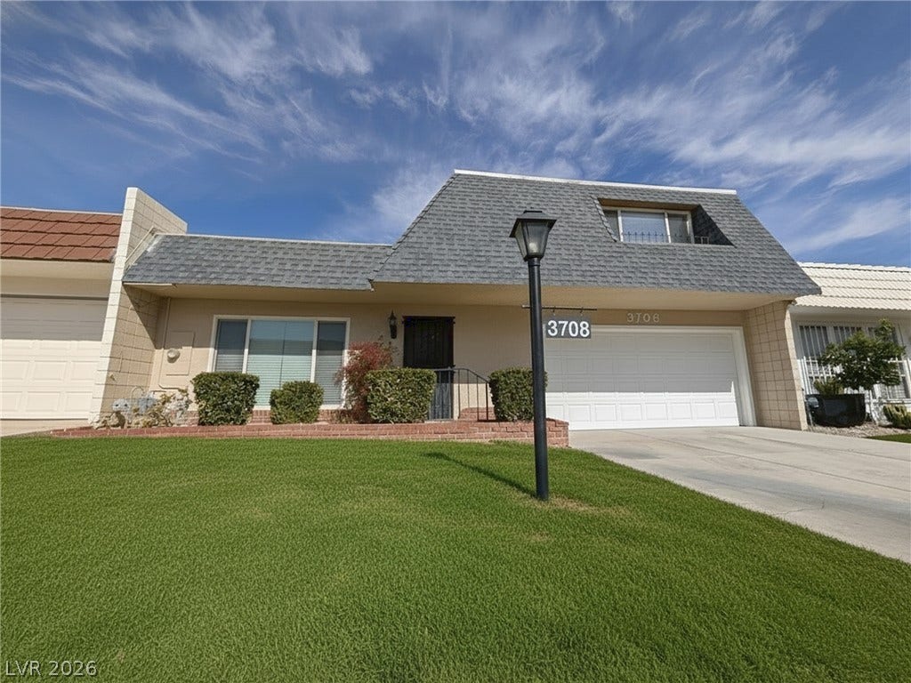 3708 Heritage Avenue, Las Vegas, NV 89121 Manicured green lawn frames this unique mansard-roofed residence with an attached garage.