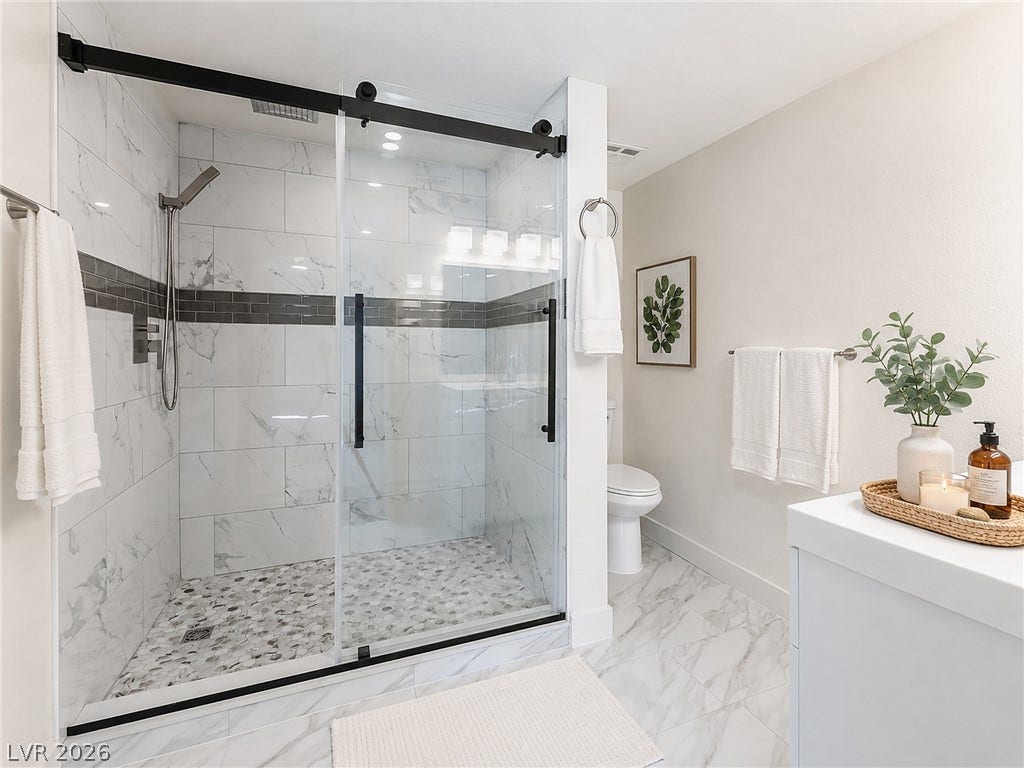 3708 Heritage Avenue, Las Vegas, NV 89121 Elegant tile details and a modern glass shower define this refreshed bath space.