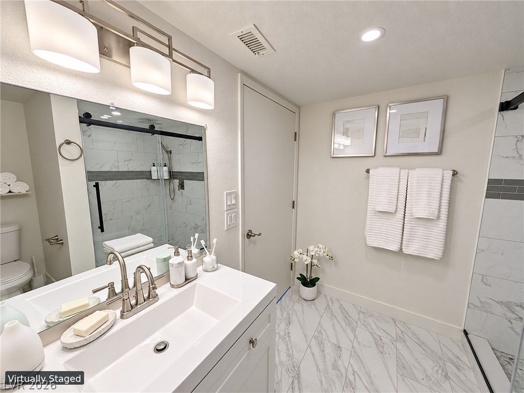 3708 Heritage Avenue, Las Vegas, NV 89121 Elegant tile flooring and modern fixtures define this beautifully updated washroom space.
