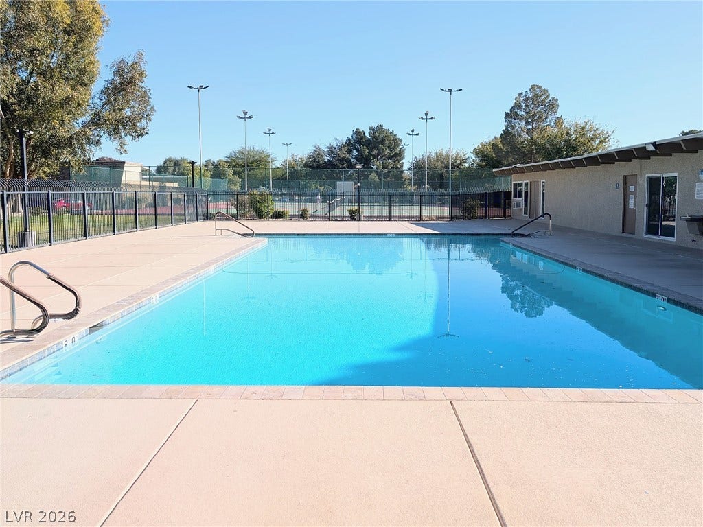3708 Heritage Avenue, Las Vegas, NV 89121 An inviting swimming pool sits adjacent to community tennis courts under a clear blue sky.