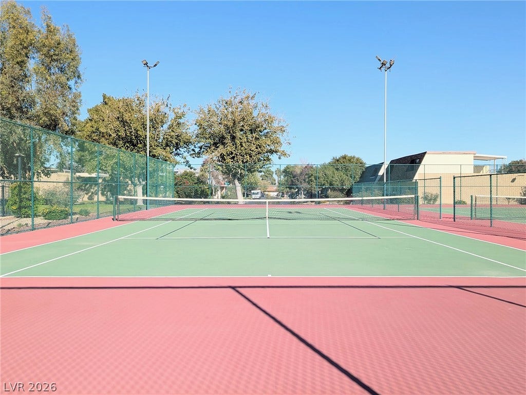3708 Heritage Avenue, Las Vegas, NV 89121 Professional-grade outdoor tennis courts feature overhead lighting and secure perimeter fencing under clear blue skies.