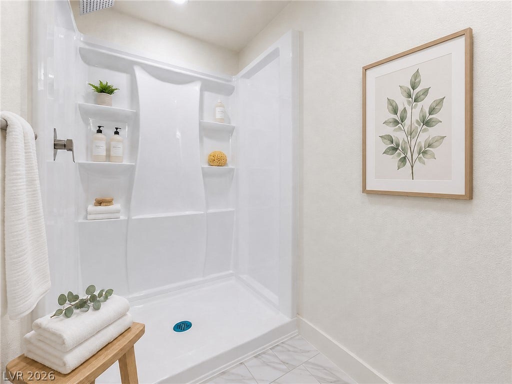 3708 Heritage Avenue, Las Vegas, NV 89121 A modern walk-in shower insert pairs beautifully with elegant marble-look tile flooring.