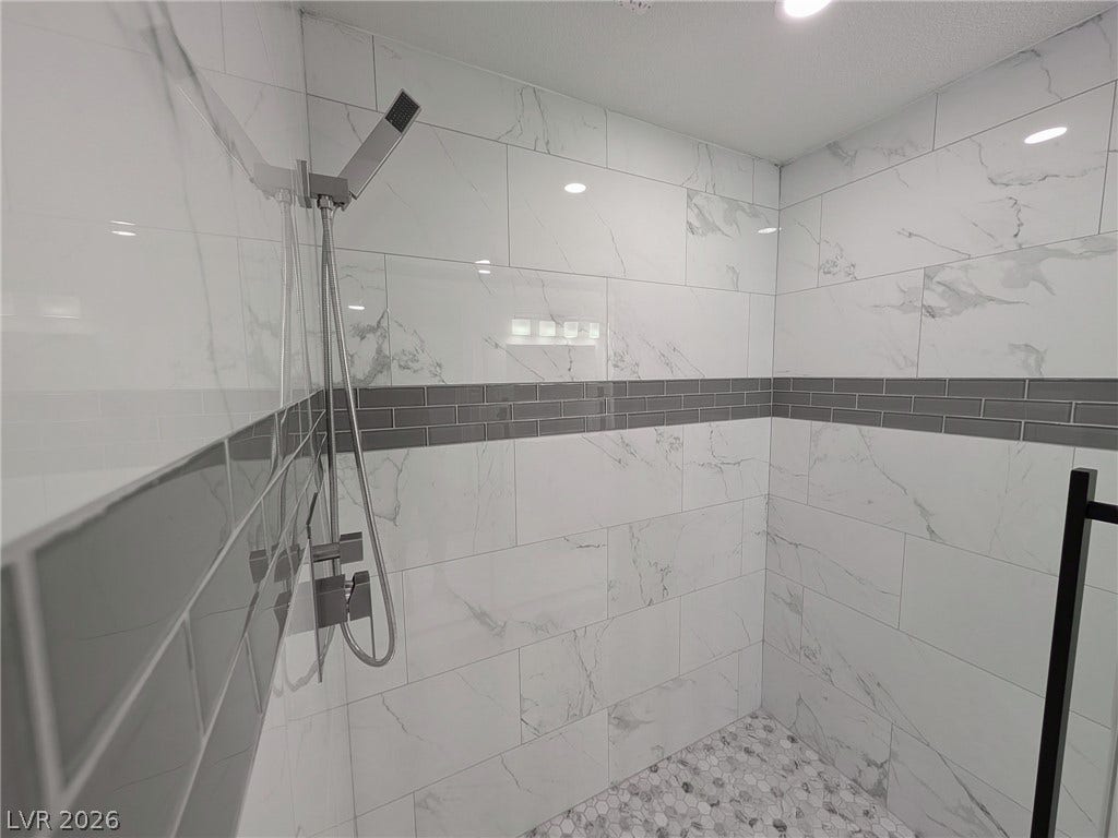3708 Heritage Avenue, Las Vegas, NV 89121 Elegant tilework and modern fixtures define this walk-in shower space.