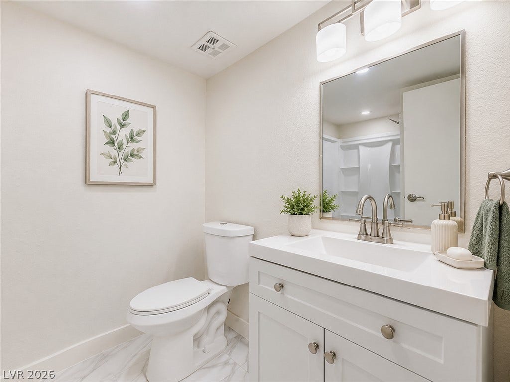 3708 Heritage Avenue, Las Vegas, NV 89121 A contemporary vanity and modern fixtures elevate this sleek bathroom space.