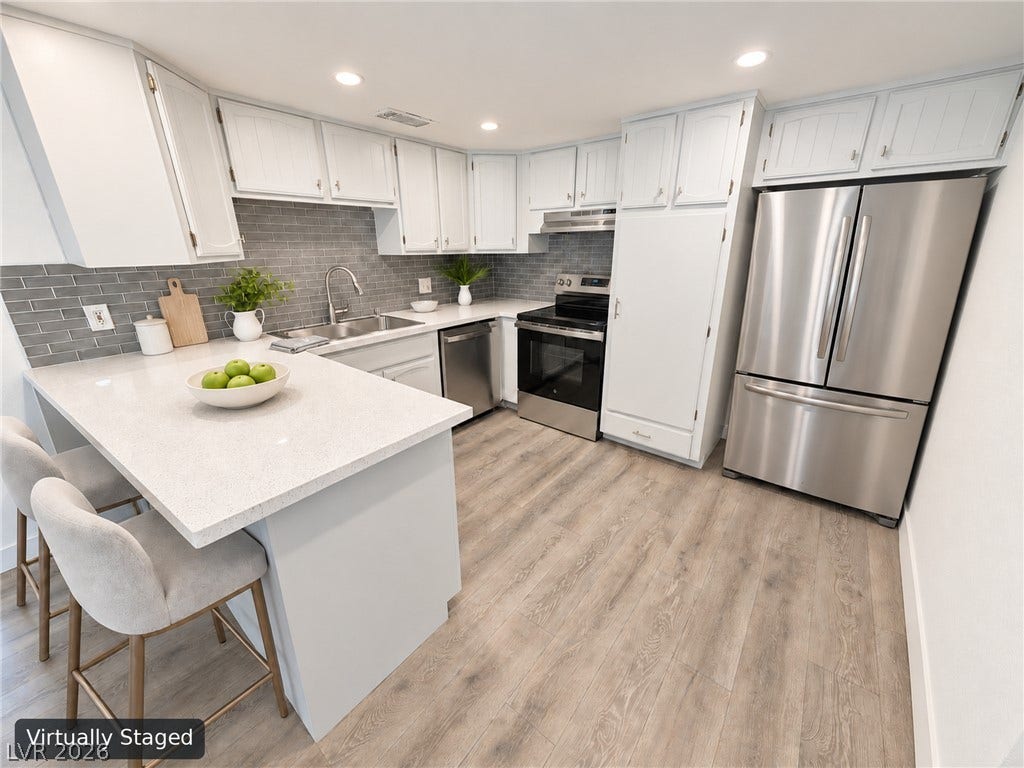 3708 Heritage Avenue, Las Vegas, NV 89121 Streamlined cabinetry and gleaming countertops anchor this updated workspace with durable wood-look flooring.