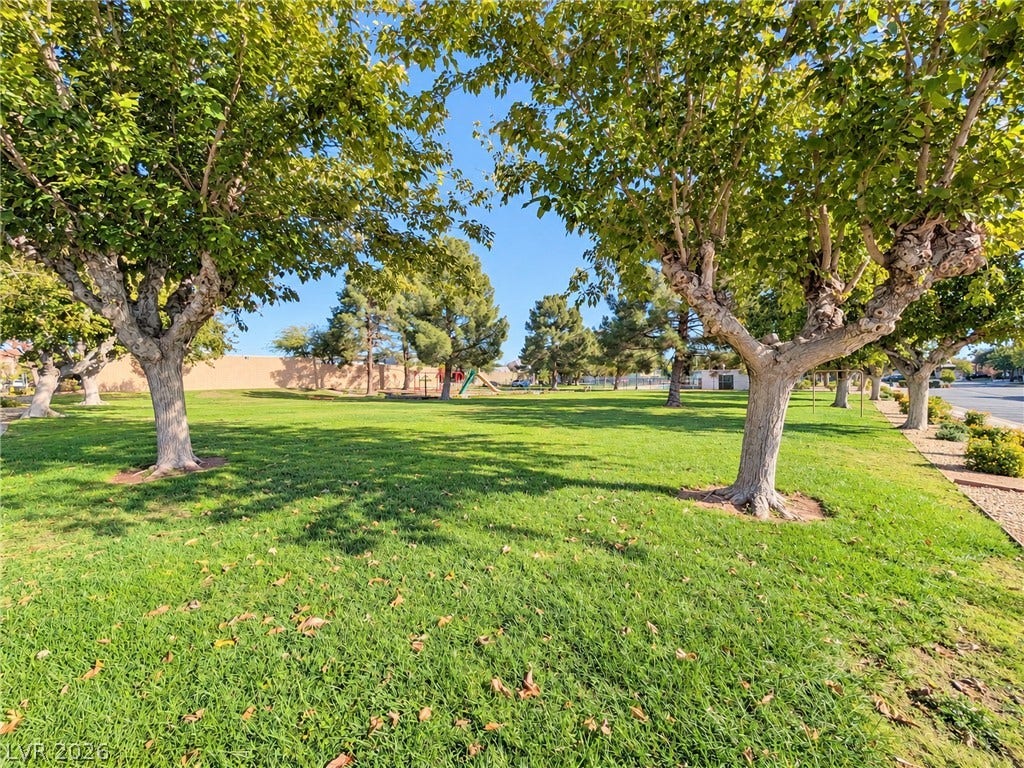 3708 Heritage Avenue, Las Vegas, NV 89121 Mature trees shade a manicured grassy common area featuring a playground in the distance.