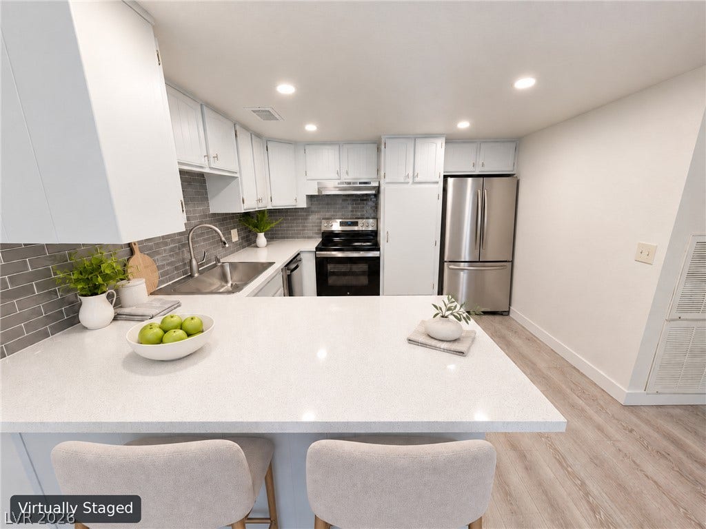 3708 Heritage Avenue, Las Vegas, NV 89121 Modern stone countertops and sleek cabinetry elevate this inviting, open culinary space.
