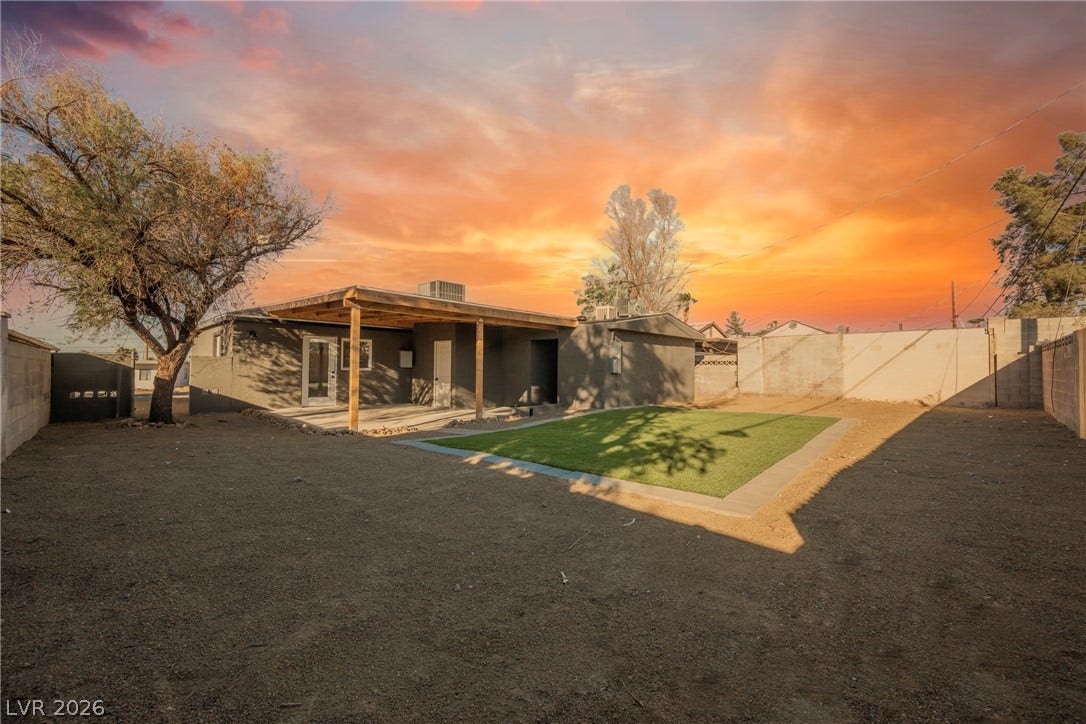 223 W Basic Road, Henderson, NV 89015 A spacious backyard features a covered patio and a pristine green lawn section.