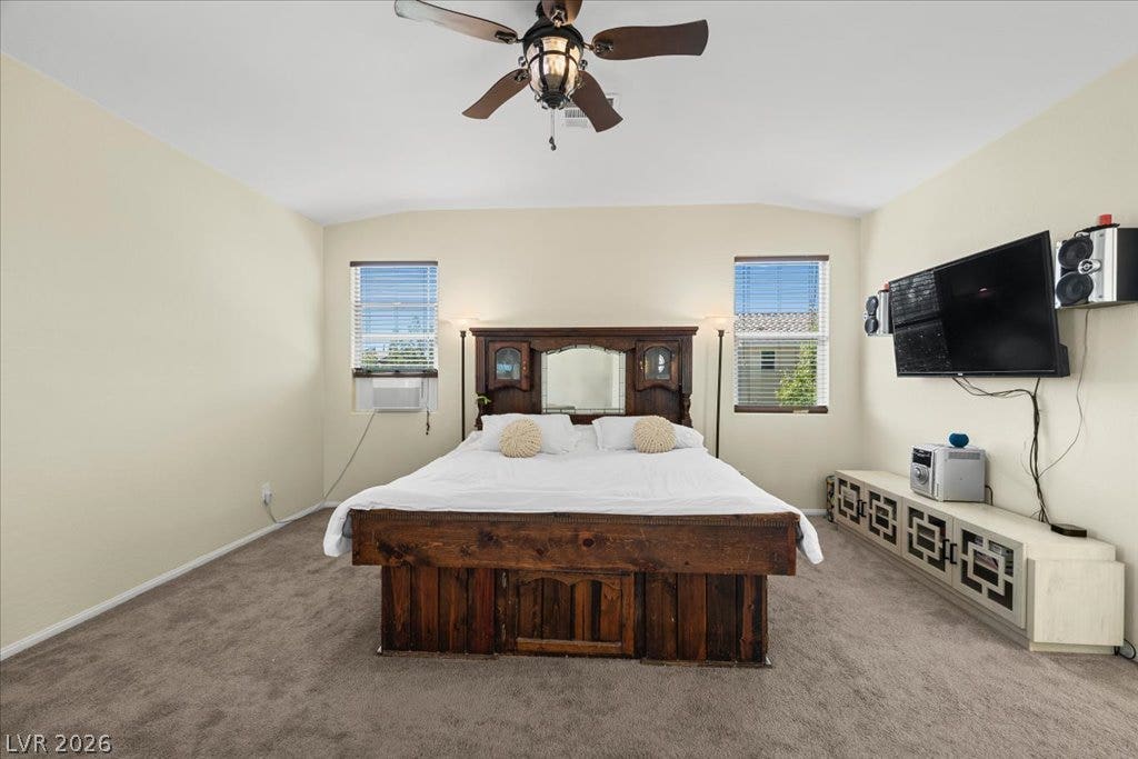 Plentiful natural light enters through twin windows in this comfortable bedroom featuring soft carpeting.