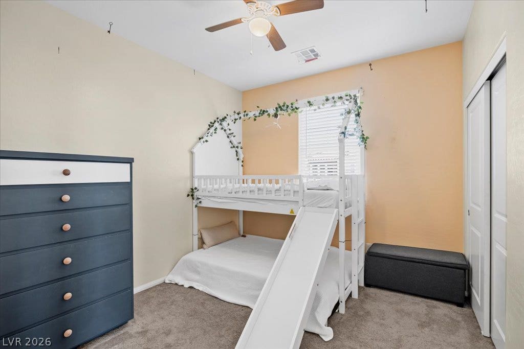Soft carpeting and a classic sliding closet door anchor this comfortable bedroom space.