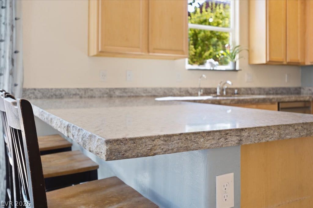 3" granite counters with natural edge complete this breakfast bar and beautify the kitchen accenting the 42" cabinetry in this functional kitchen space.