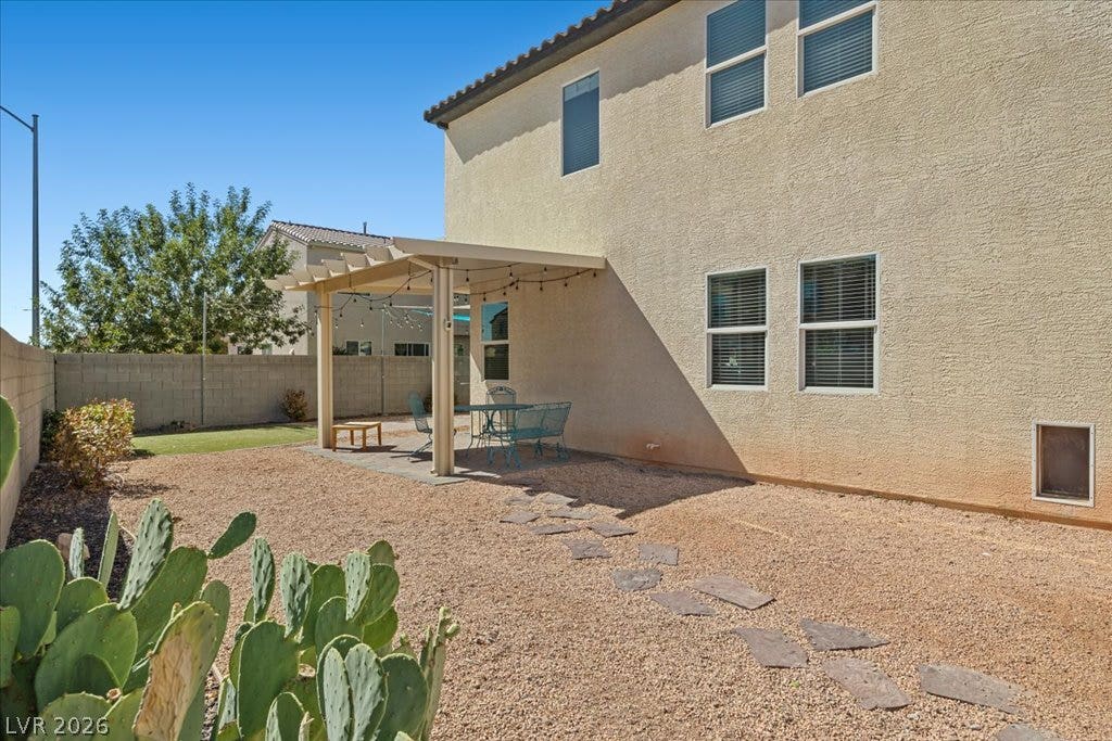 A stone pathway guides you across the low-maintenance desert yard to the covered patio space.