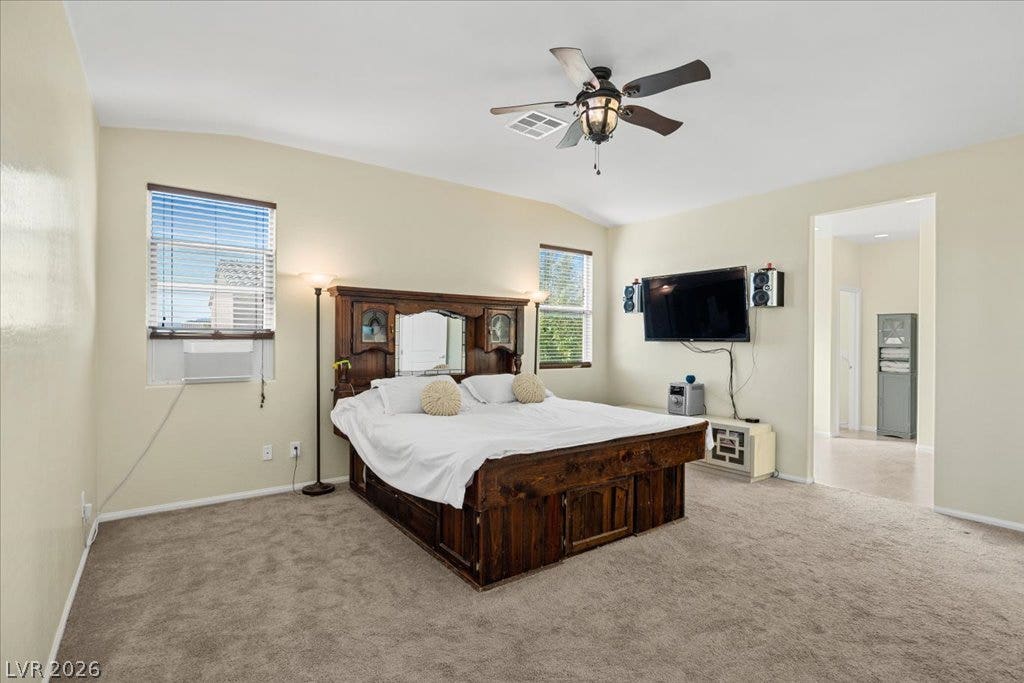 Plush carpeting and vaulted ceilings enhance the open layout of this comfortable bedroom.