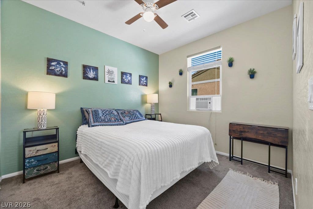 Plush carpeting and a high ceiling establish a comfortable atmosphere in this peaceful bedroom.