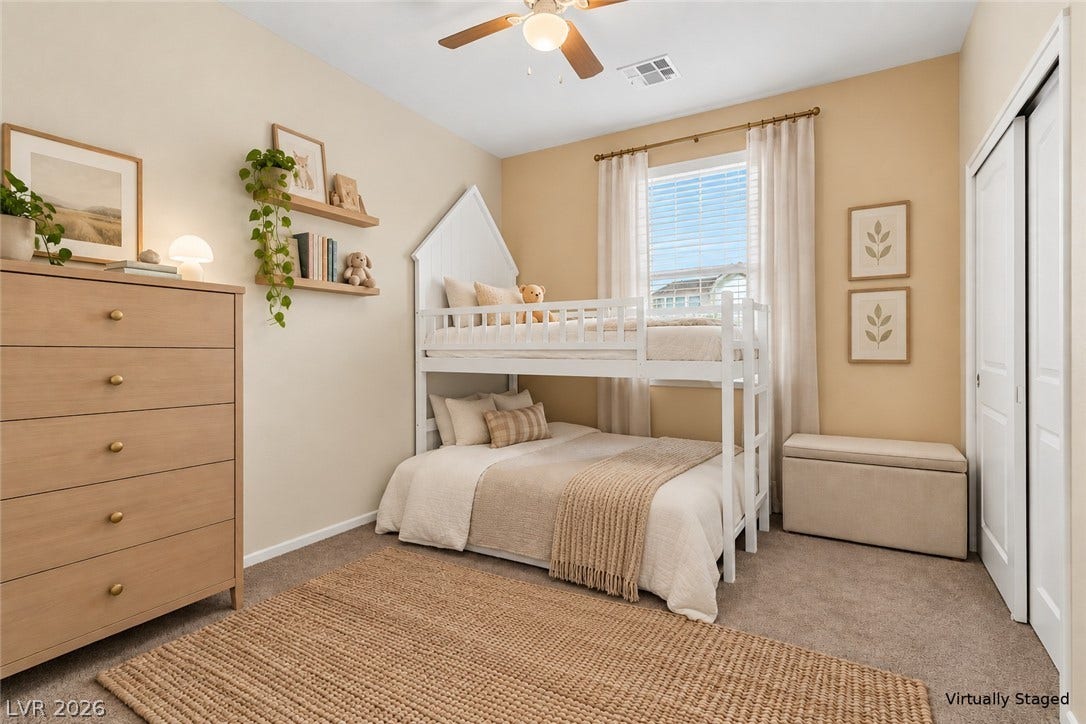 Soft carpet and a bright window define this comfortable secondary bedroom.