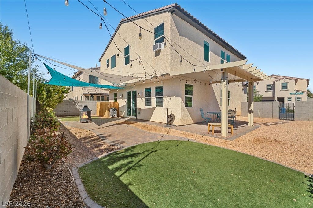 A spacious backyard features a pavers, Alumawood covered patio, shaded canopies, and green turf area.