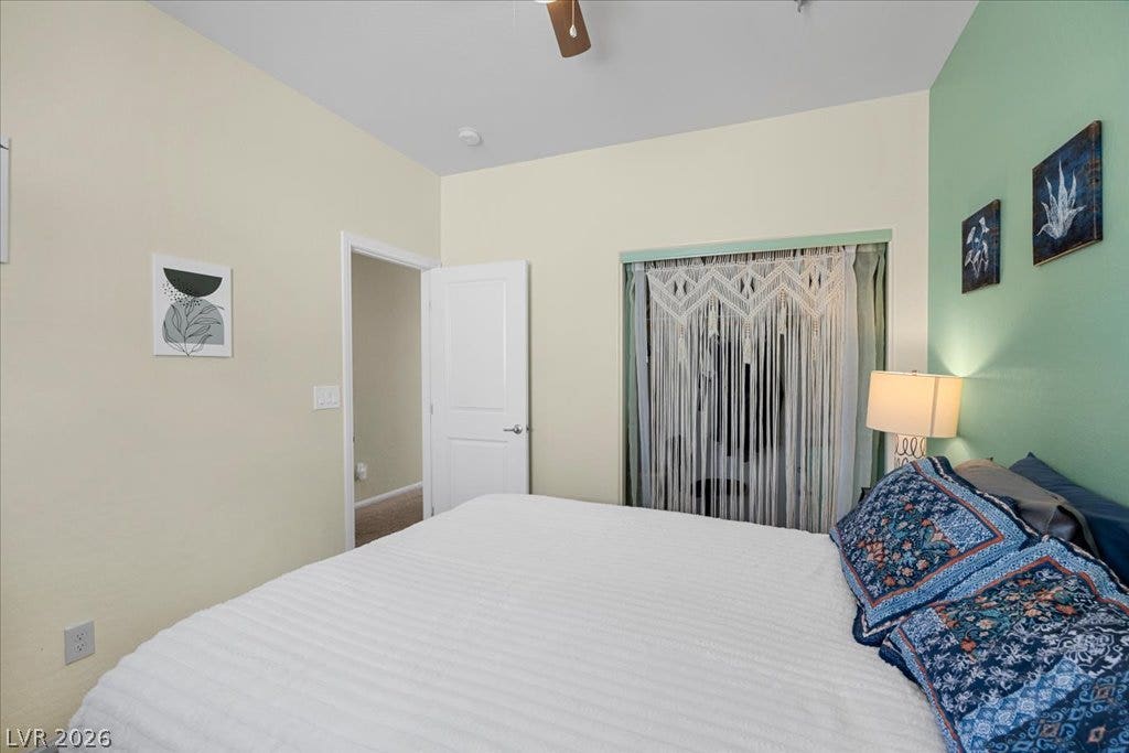 High ceilings and a large window create an airy feeling in this quiet bedroom.