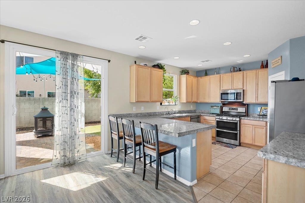 Sliding glass doors connect the spacious open kitchen directly to the rear patio.