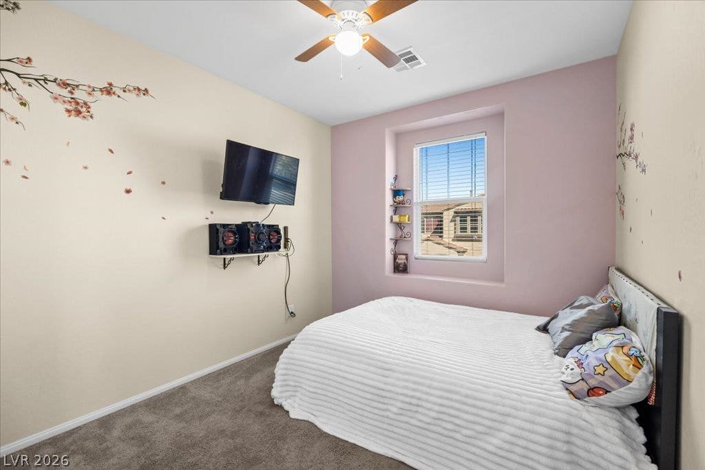 Plush carpeting and a deeply recessed window enhance this cozy secondary bedroom.