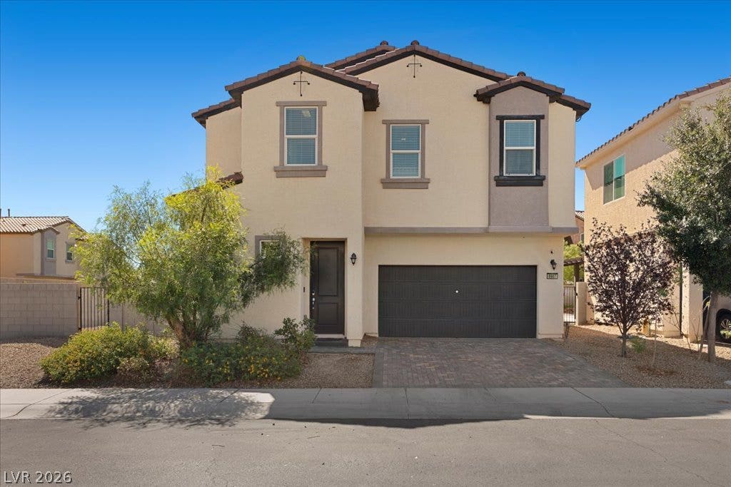 An inviting two-story stucco exterior features a tile roof and a private front entrance.