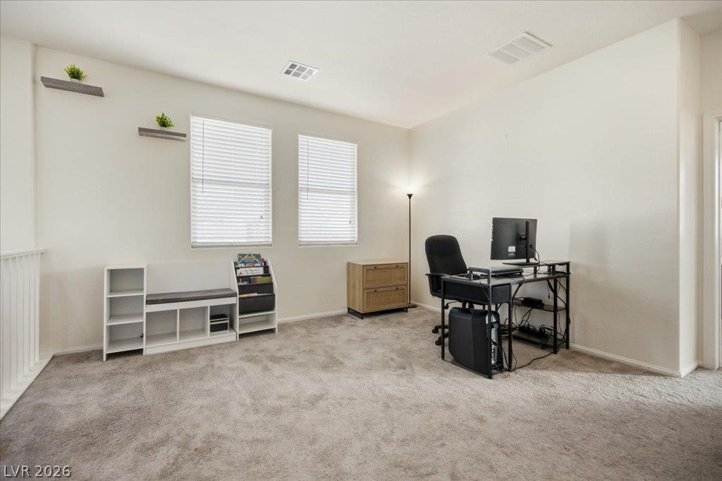 Plentiful natural light and plush carpeting define this versatile upstairs loft space.