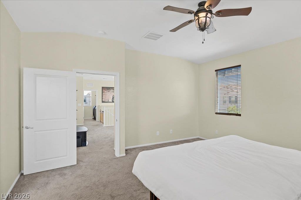 Soft carpeting underfoot and high vaulted ceilings create a relaxing atmosphere in this upper-level bedroom.