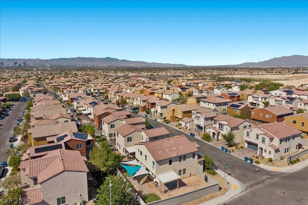 Sweeping neighborhood views stretch toward the distant mountains under clear blue desert skies.