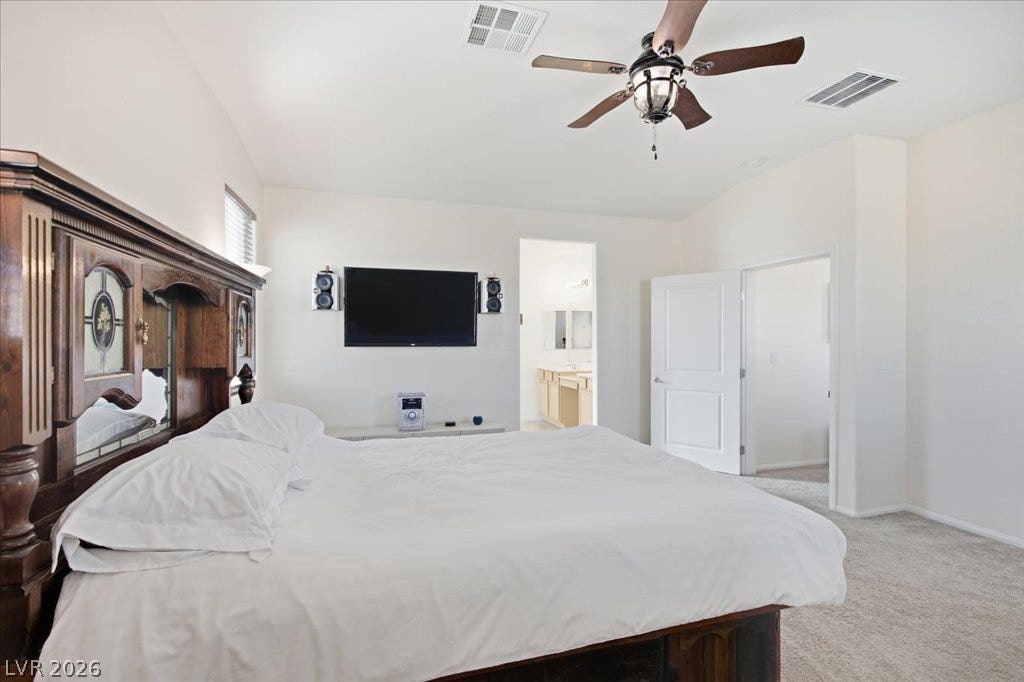 High ceilings and soft carpeting define this comfortable bedroom suite with an attached bathroom.