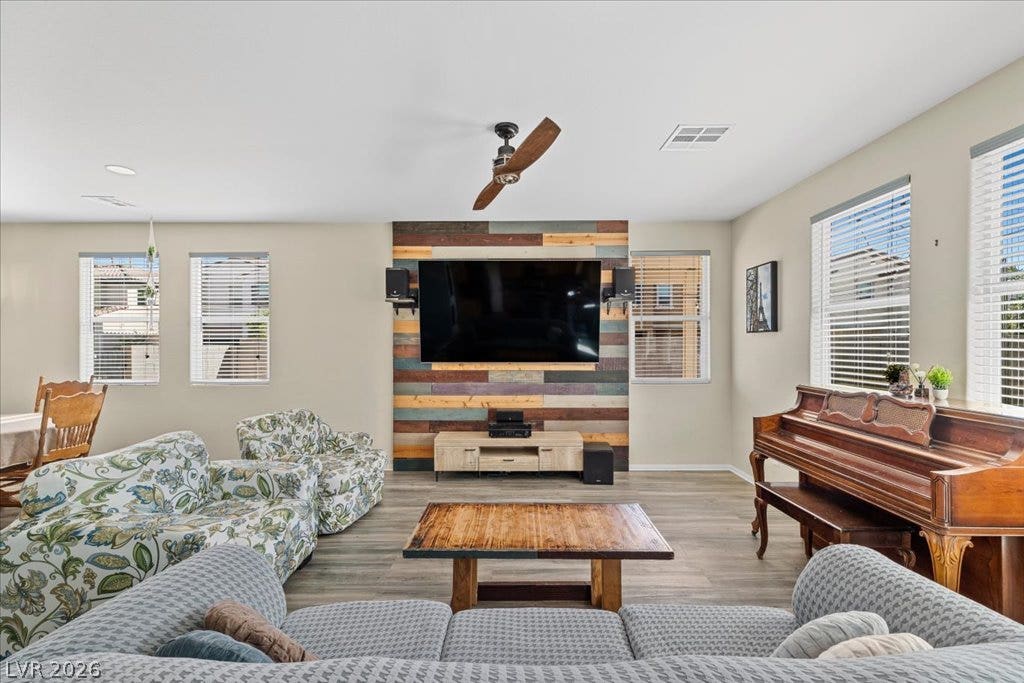 Smooth waterproof laminate floors anchor this open living area featuring a rustic wood accent wall.